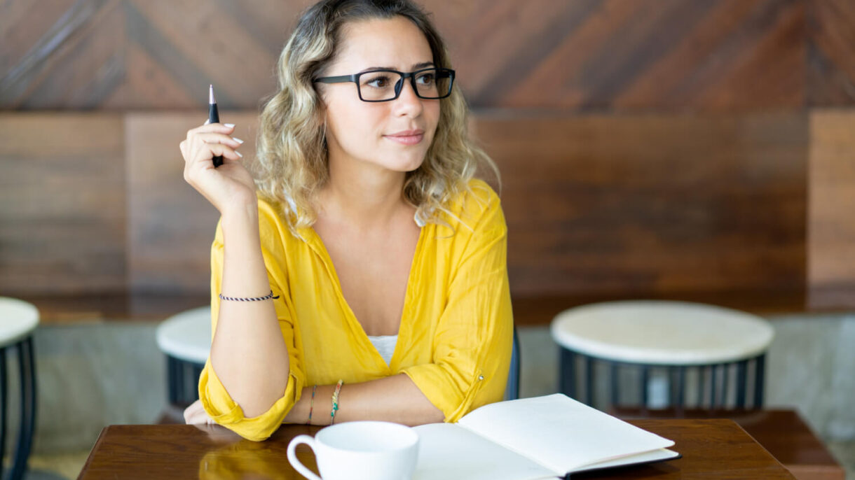 pretty curly young woman writing notes startup project